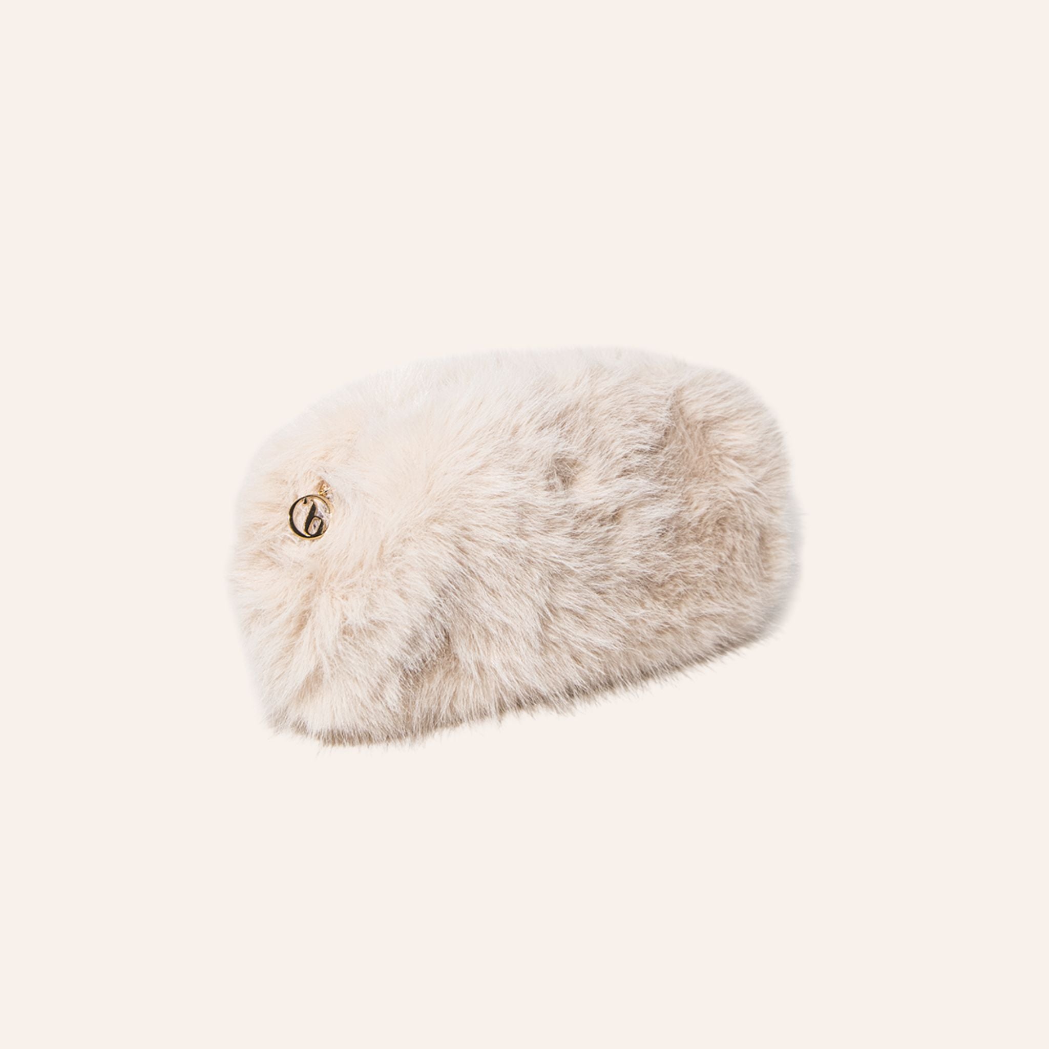 A fluffy faux fur pouch in a light cream color with a small gold interlocking G logo on the side, set against a solid off-white background.