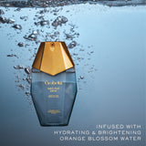 Orabelle Nectar Dew bottle with gold cap underwater on a blue gradient background