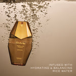 Orabella Vanilla's Touch perfume bottle floating in water with bubbles around it, set against a warm beige background with text reading 'INFUSED WITH HYDRATING & BALANCING RICE WATER'.