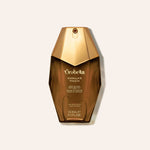 A bottle of Orabella Vanilla Touch body wash in a faceted metallic gold bottle, centered on a light beige background.