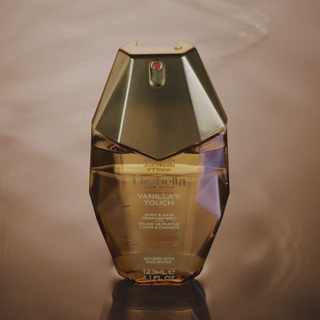 Video demonstrating how to use the Vanilla's Touch Body & Hair Perfume Mist. A hand slides the lock on the back of cap to ON position, then shakes the mist to fully blend the bi-phase formula. The bottle is then sprayed liberally.